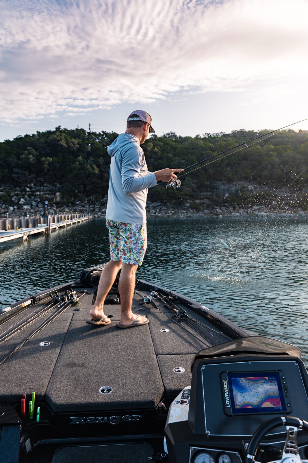 An angler casting from the bow of the boat into schooling fish at first light